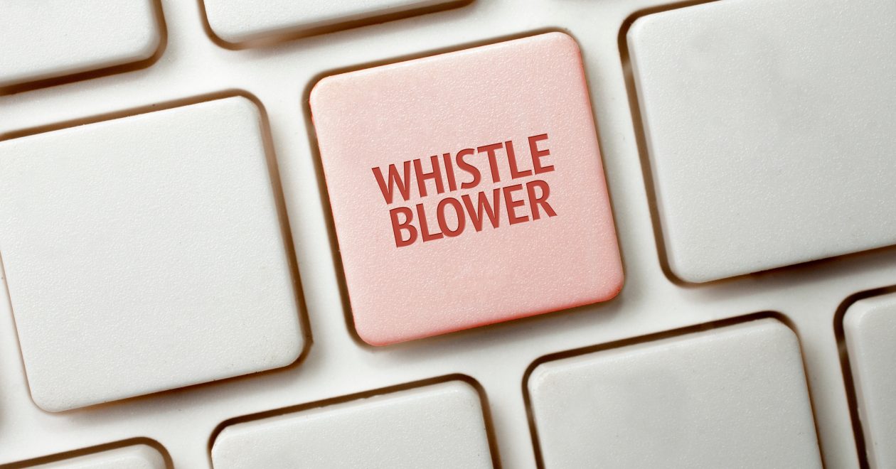 Una tastiera bianca con un tasto rosso che riporta la parola whistleblower
