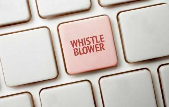 Una tastiera bianca con un tasto rosso che riporta la parola whistleblower